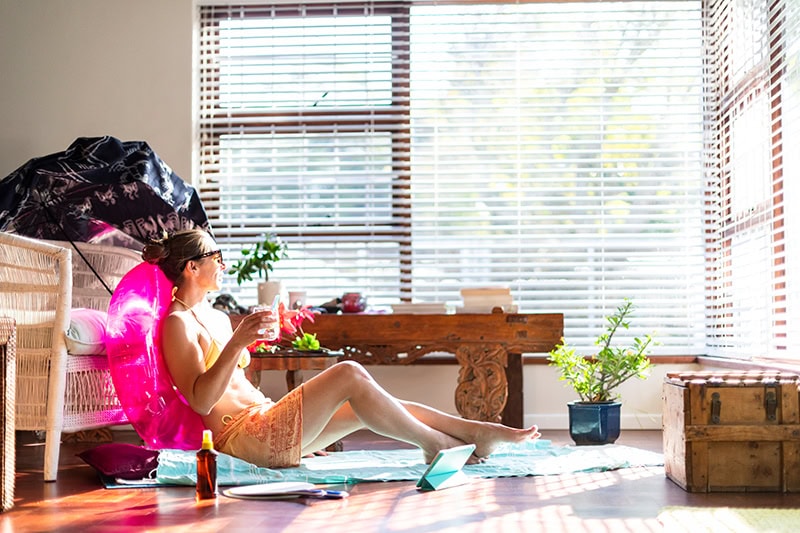 Young woman sitting in her living room with a pool floaty.