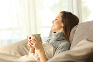 Pensive woman relaxing at home with a cup of coffee