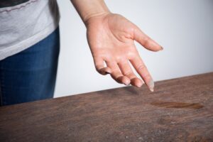 Person with dust on their finger after wiping a table.